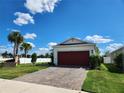 Exterior view of a house with a red garage door and a paved driveway at 11883 Brighton Knoll Loop, Riverview, FL 33579