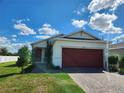 One-story house featuring a red garage door and a well-maintained lawn at 11883 Brighton Knoll Loop, Riverview, FL 33579