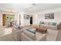 Bright living room features neutral decor, and tile flooring, offering an inviting space at 2222 Greenhaven Dr, Sun City Center, FL 33573