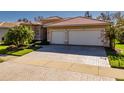 Three-car garage with herringbone driveway and landscaping at 4977 Sapphire Sound Dr, Wimauma, FL 33598