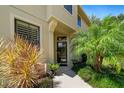 Inviting entrance with lush landscaping, a covered porch, and a stylish black front door at 2539 Silverback Ct, Palm Harbor, FL 34684