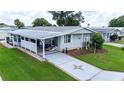 Mobile home with covered patio, landscaping, and driveway at 36750 Kimela Ave, Zephyrhills, FL 33542