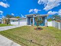 Newly built home with a gray exterior, modern garage, and landscaped lawn at 2115 W Idlewild Ave, Tampa, FL 33603