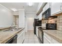 Clean kitchen with white cabinetry, black appliances, and tiled floor at 5608 Pinnacle Heights Cir # 305, Tampa, FL 33624