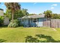 Inviting light blue house with a spacious yard and palm trees at 6030 62Nd N St, St Petersburg, FL 33709