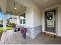 Inviting front porch with a cozy swing, stone accents, and a welcoming entrance at 11828 Ranchers Gap Dr, Odessa, FL 33556