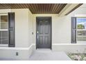 Dark brown front door with sidelights and shutters at 4013 Chadwick Ave, Spring Hill, FL 34609