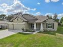 New construction home with a 3-car garage and landscaped lawn at 4013 Chadwick Ave, Spring Hill, FL 34609