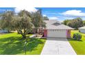 Brick ranch home with a large grassy yard and driveway at 1804 New Bedford Dr, Sun City Center, FL 33573