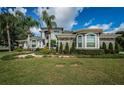 Well-maintained lawn and landscaping leading up to the exterior of this two-story home at 180 Keystone Palms Blvd, Tarpon Springs, FL 34688