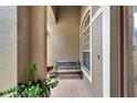 Inviting, covered porch features brick flooring, a wooden bench, and a view of the entryway at 1926 Rutherford Dr, Dover, FL 33527