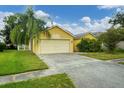 House exterior showcasing a yellow facade, garage, and driveway at 1122 Vinetree Dr, Brandon, FL 33510