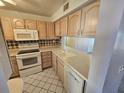 Bright kitchen with white appliances and wood cabinets at 6322 Palma Del Mar S Blvd # 215, St Petersburg, FL 33715