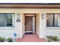 Inviting front entrance with a brown door and brick walkway at 12408 N 52Nd St, Temple Terrace, FL 33617