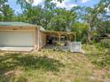 Features a well-maintained attached garage, adjacent to an open, wooden-roofed patio at 26831 Chianina Dr, Wesley Chapel, FL 33544