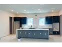Modern kitchen featuring a large island, sleek cabinetry, and bright natural light from the windows at 4716 W Euclid Ave, Tampa, FL 33629