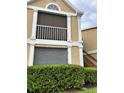 Exterior view of building showing a tan building with white accents, balcony, and landscaping at 9481 Highland Oak Dr # 505, Tampa, FL 33647