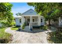 Charming bungalow home with blue siding, a welcoming front porch, and decorative landscaping at 860 19 N Ave, St Petersburg, FL 33704