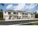 Front view of a three-story townhome with attached garages and neutral color scheme at 11412 Crescent Deer Dr, Land O Lakes, FL 34638