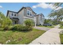 Two-story house with gray siding, two-car garage, and manicured lawn at 2848 Gridiron Isle, New Port Richey, FL 34655