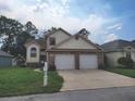 Two-story house with a two-car garage and landscaping at 10908 Claymont Dr, New Port Richey, FL 34654