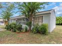 Side view of a charming gray ranch home with mature shrubs and a well-maintained lawn at 4407 W Bay Villa Ave, Tampa, FL 33611