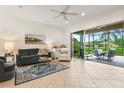 Bright living room with tile flooring, ceiling fan, and seamless access to the screened patio at 15911 Cobble Mill Dr, Wimauma, FL 33598