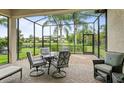 Relaxing screened patio with outdoor seating and a view of the lush backyard and pond at 15911 Cobble Mill Dr, Wimauma, FL 33598
