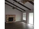 Living room with a stone fireplace and wood beams at 15704 Almondwood Dr, Tampa, FL 33613