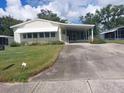 Front view of a yellow manufactured home with a carport at 197 Philadelphia Blvd # 26, Palm Harbor, FL 34684
