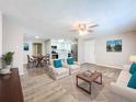 Bright living room with hardwood floors, neutral paint, ceiling fan, and open concept floor plan at 1709 E Sitka St, Tampa, FL 33604