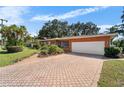 Ranch-style house with orange brick exterior, white garage door, and landscaped yard at 2505 E 19Th Ave, Tampa, FL 33605