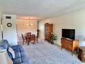 Living room with comfy blue couch, dining table, and wood cabinet at 2385 Tahitian Ln # 63, Clearwater, FL 33763