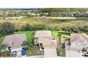 Aerial view of a two story house with a large backyard and surrounding nature at 5806 Candytuft Place, Land O Lakes, FL 34639