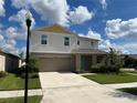Two story house with light beige siding and teal door at 13116 Shumard Way, Riverview, FL 33579