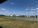 A beautiful view of the serene backyard with a tranquil pond and community homes at 10736 Tippecanoe Pl, Parrish, FL 34219