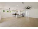 Open-concept living space with tile floors, modern lighting, and a stylish kitchen featuring an island at 11892 Frost Aster Dr, Riverview, FL 33579
