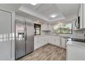 Modern kitchen with white shaker cabinets, stainless steel appliances, and gray tile flooring at 107 Seville N Ct, Plant City, FL 33566