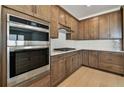 Contemporary kitchen features stainless steel appliances, light countertops, and wooden cabinets at 13715 Brookside Haven St, Riverview, FL 33578