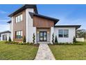 Modern home with wood and white exterior, landscaping, and walkway at 2855 Sunstream Ln, Clearwater, FL 33759