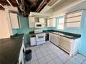 Kitchen with white cabinets and teal countertops needing updates at 17025 Dalberg Dr, Spring Hill, FL 34610
