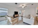 Living room with white couch, two armchairs, and a TV at 6406 Bar S Bar Trl, Zephyrhills, FL 33541