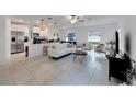 Open living room with white couch and kitchen island at 6406 Bar S Bar Trl, Zephyrhills, FL 33541