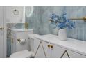 Elegant bathroom featuring blue marble style tile, gold hardware, and a modern floating sink at 11452 81St Pl, Seminole, FL 33772