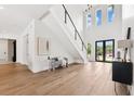 Open foyer with soaring ceilings, a modern staircase with black metal, light wood floors, and natural light at 4625 W El Prado Blvd, Tampa, FL 33629