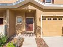 Close up of the home's front entrance with garage door and mulched yard in view at 12820 Belvedere Song Way, Riverview, FL 33578