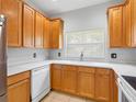 Beautiful kitchen featuring wooden cabinets, white appliances, and a double basin sink at 12820 Belvedere Song Way, Riverview, FL 33578