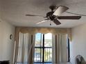 Living room with window coverings, ceiling fan, and water views at 255 Dolphin Pt # 909, Clearwater, FL 33767