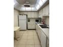 Efficient kitchen featuring white cabinets, appliances, and tile flooring at 255 Dolphin Pt # 909, Clearwater, FL 33767