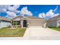 Inviting home with a two-car garage, lush landscaping, and manicured lawn at 1523 Glen Grove Loop, Wesley Chapel, FL 33543
